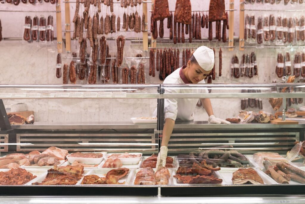personal atendiendo en mostrador de carne steel inox